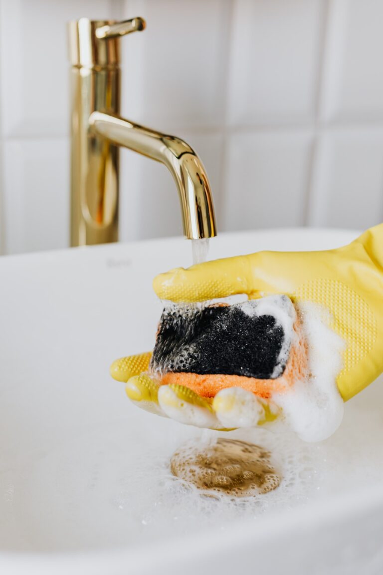 Cleaner rinsing sponge in bathroom sink